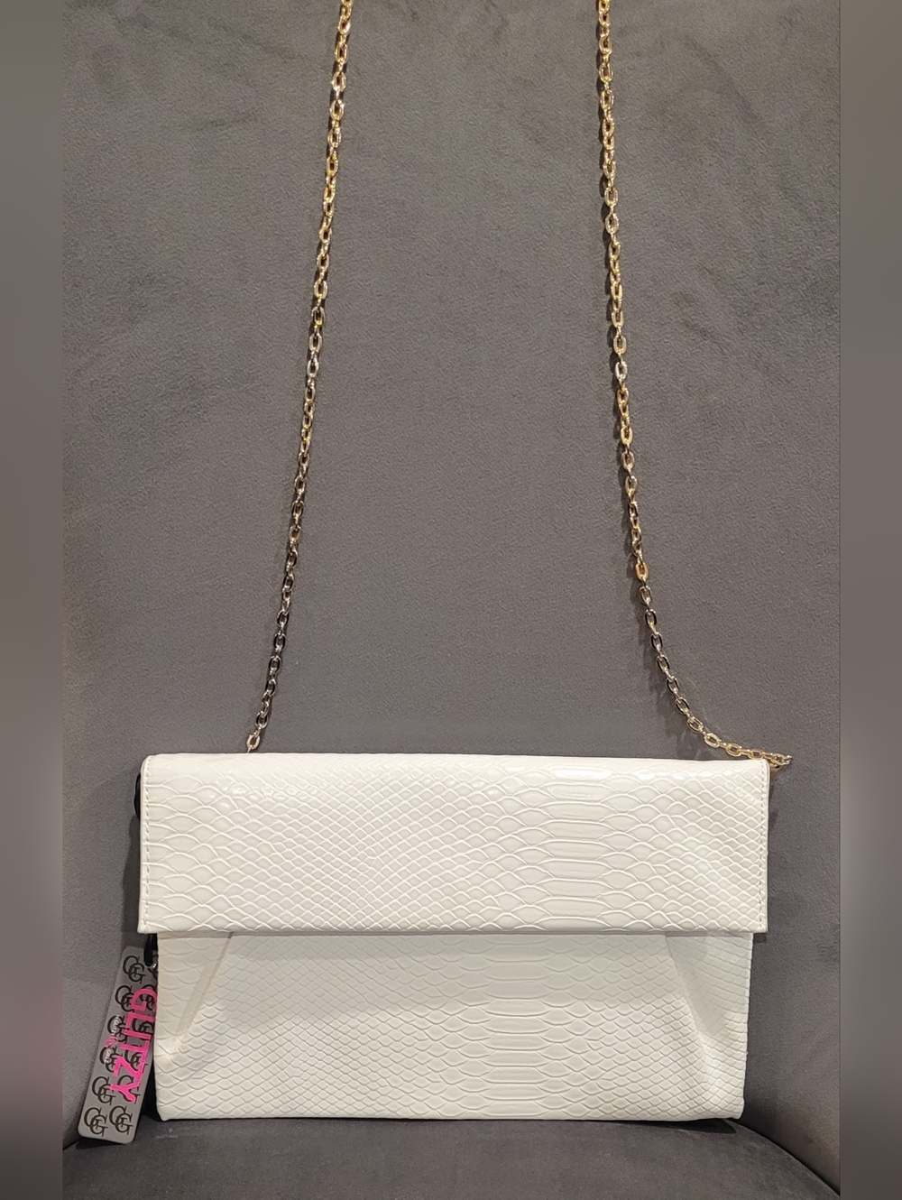Leather clutch bag with chain strap and 'GLITZY' tag, white